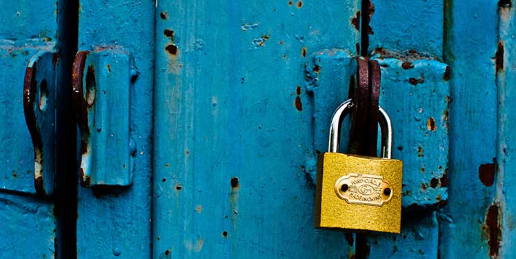 A gold lock on a blue door.